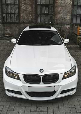 White BMW parked near brick building