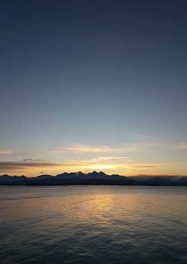 Sunset over water with mountain backdrop