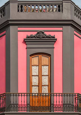 Pink building with wooden door and balcony