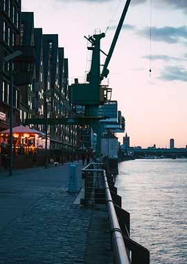 Riverside Cityscape with Crane at Dusk