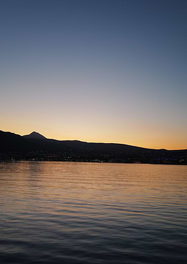 Sunset over water with mountain silhouette