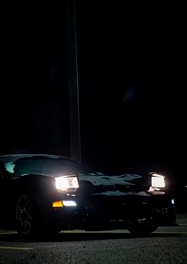 Black C5 corvette Car at Night with Headlights On