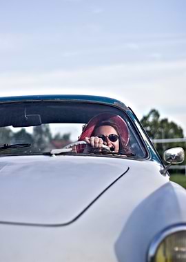 Woman driving vintage car with hat