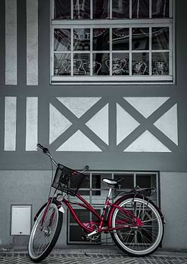 Red Bicycle Against Gray Building Facade