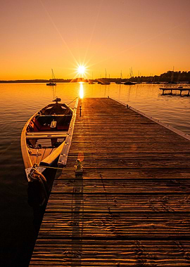 Sunset over lake with boat and pier