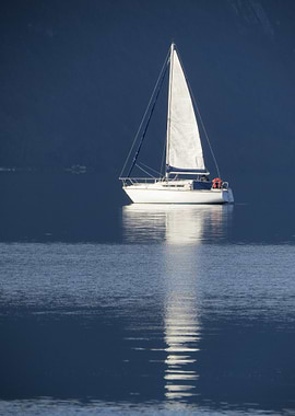 Sailboat on calm water, mountain backdrop