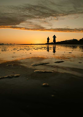 Sunset beach with silhouettes of people
