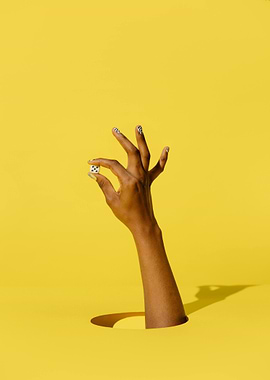 Hand Holding Dice on Yellow Background