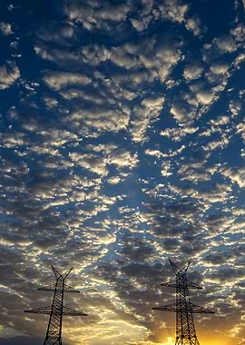 Power Lines Under Cloudy Sky at Sunset