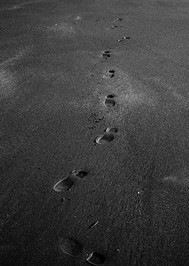 Footprints on a dark beach