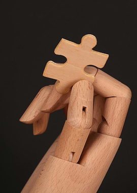 Wooden Hand Holding Puzzle Piece