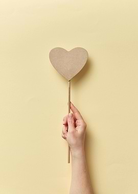 Hand holding a heart on a stick
