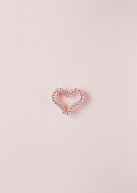 Heart-shaped hair tie on pink background