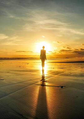 Woman walking on beach at sunset