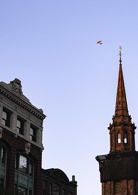 Airplane over City Buildings and Church
