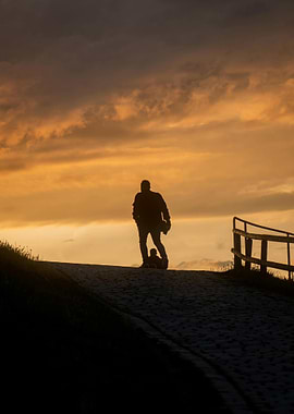 Silhouette of man and child at sunset