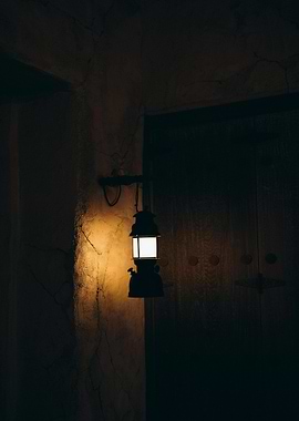 Illuminated Lantern Against Dark Wall