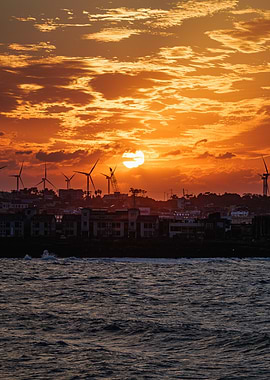 Sunset over coastal town with windmills