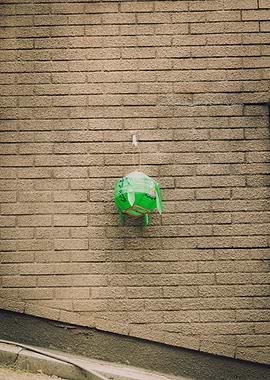Green Lantern Hanging on Brick Wall