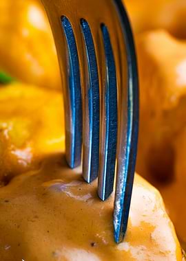 Fork in food with orange sauce