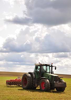 Green Tractor in Field Under Cloudy Sky