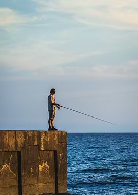 Fisherman on a pier at sunset