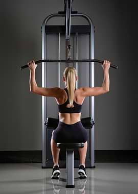 Woman using lat pulldown machine