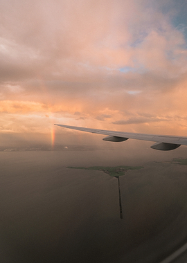 Airplane view with rainbow and island