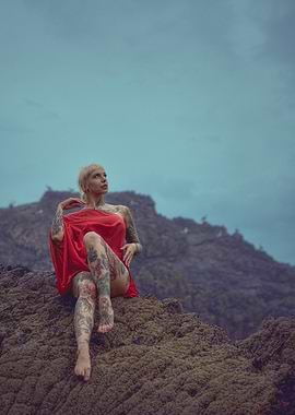 Tattooed Woman in Red on Rocks