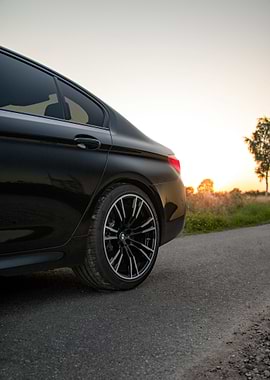 Black BMW M5 on Road at Sunset