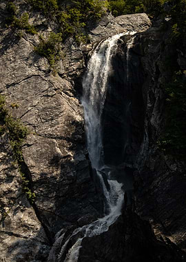 Waterfall cascading down rocky cliff