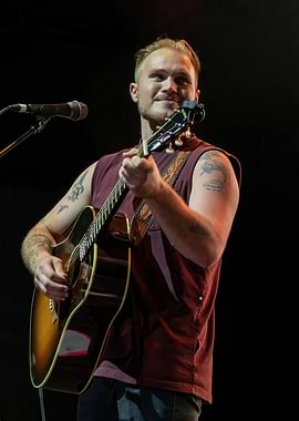 Musician playing acoustic guitar on stage