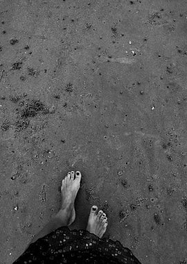 Bare feet on sandy beach, monochrome