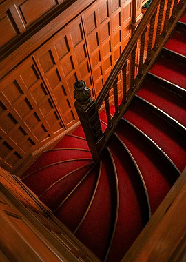 Red Carpeted Spiral Staircase with Wood Paneling