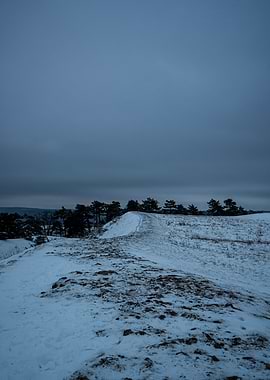 Snowy Hill Landscape Under Cloudy Sky