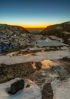 Mountain valley at sunset with snow