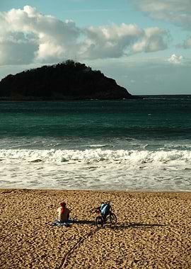 a beach, a person and thier bicycle