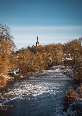 Winter river landscape with church tower