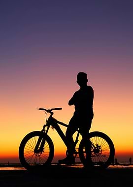 Silhouette of man with bicycle sunset