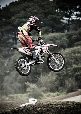 Motocross rider jumping high on dirtbike