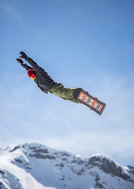 Snowboarder in mid-air against blue sky