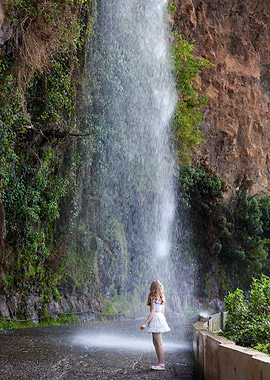 Girl standing under a waterfall