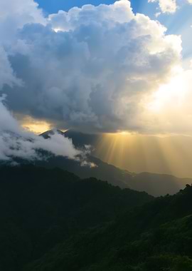 Sun Rays Through Clouds Over Mountains