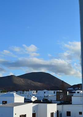 White Village of Lanzarote with Volcanic Hills Under Blue Sky