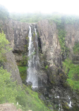 Misty Waterfall Over Rocky Cliffs