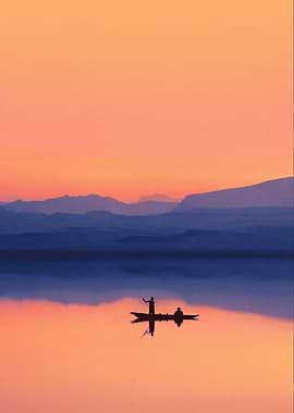 Silhouettes of people in a boat at sunset