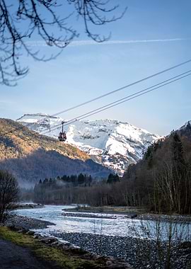 Cable Car Over Snowy Mountain River in the French Alps