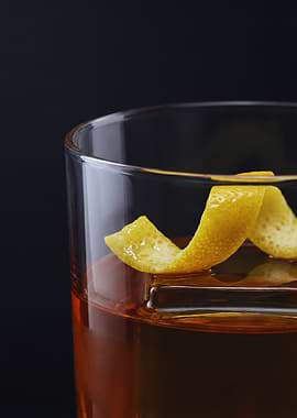 Amber Whiskey Cocktail with Lemon Twist in a Lowball Glass