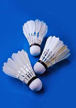 Three Badminton Shuttlecocks on Blue Background