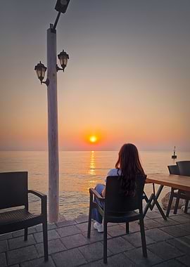 Woman watching sunset by the sea